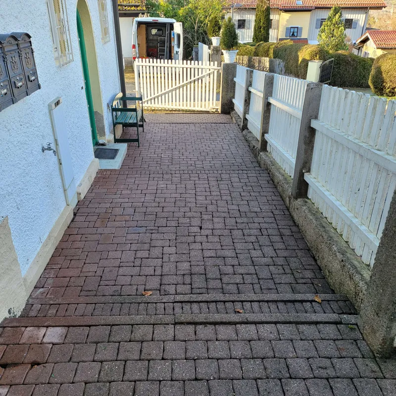 Pflasterweg am Wohnhaus als Einblick in objektnahe Pflegearbeiten