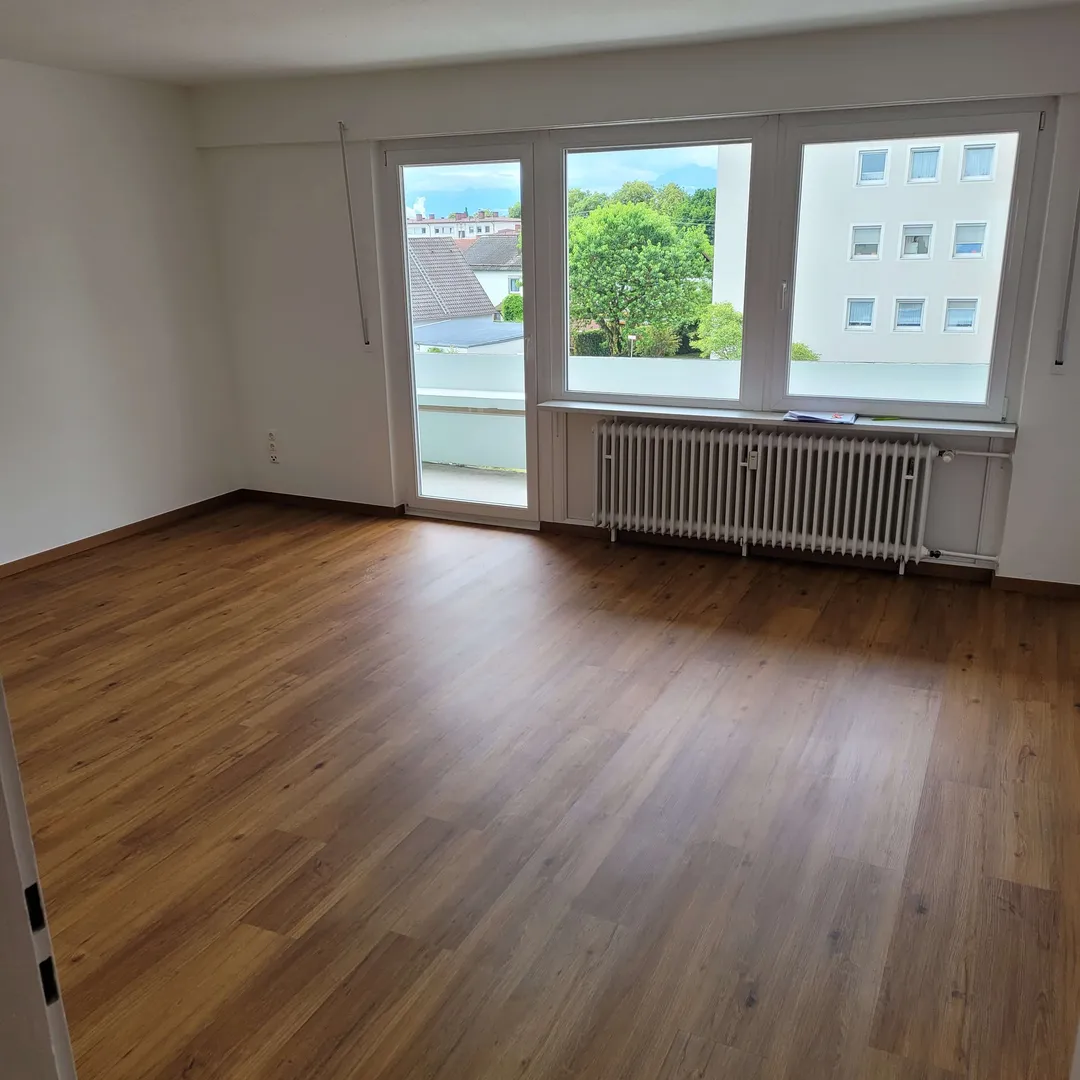 Renovierter Wohnraum mit Holzboden und hellen Wandflächen