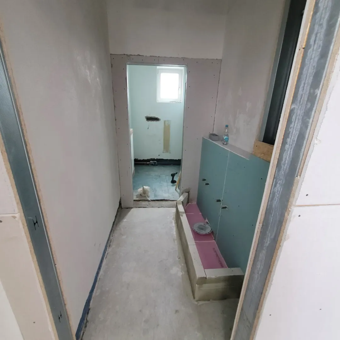 Bad im Rückbau mit freigelegten Wand- und Bodenflächen